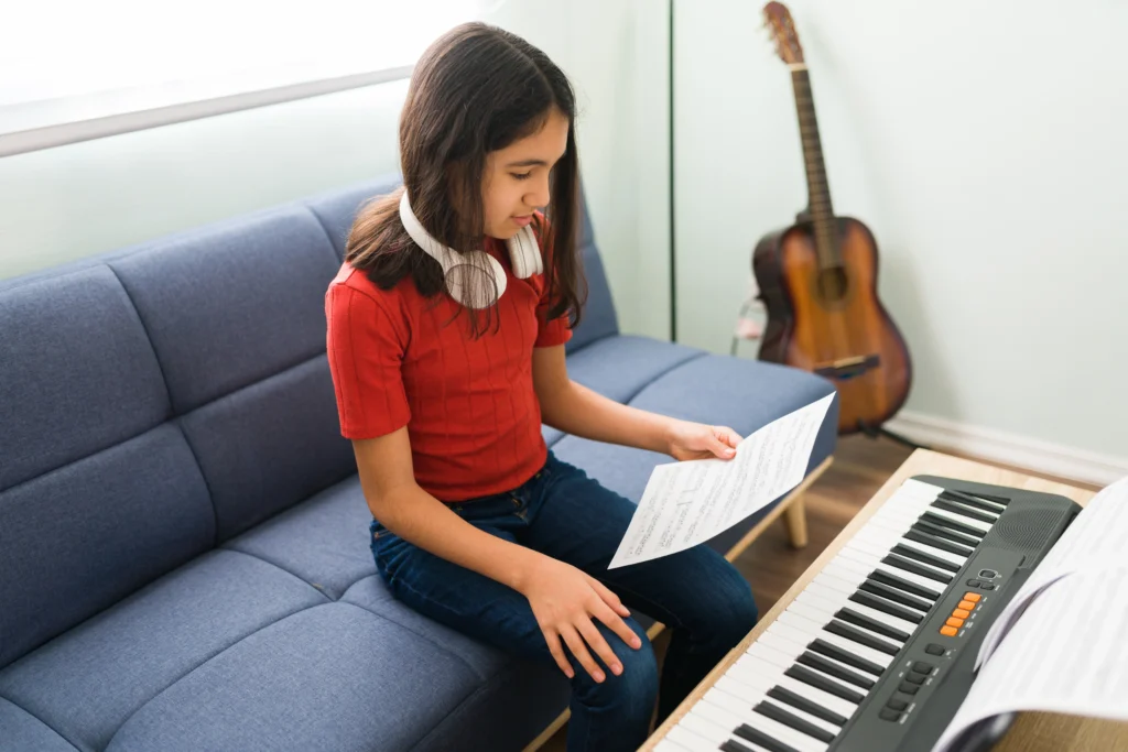 Child smiling while playing the easiest song to learn on piano