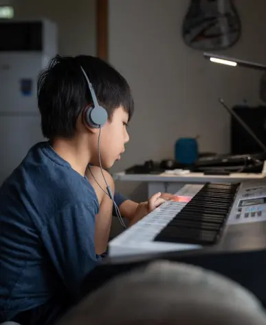Child playing an easy 3 key piano song with joy
