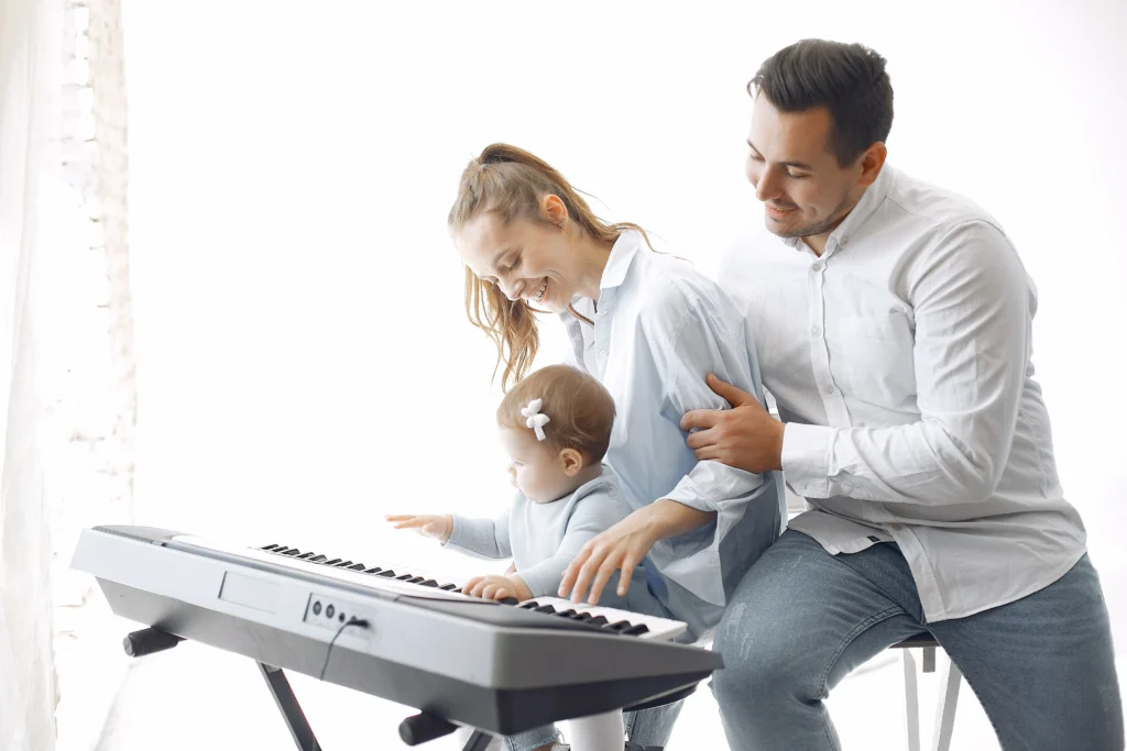 Young family gathered around a piano learning a song together