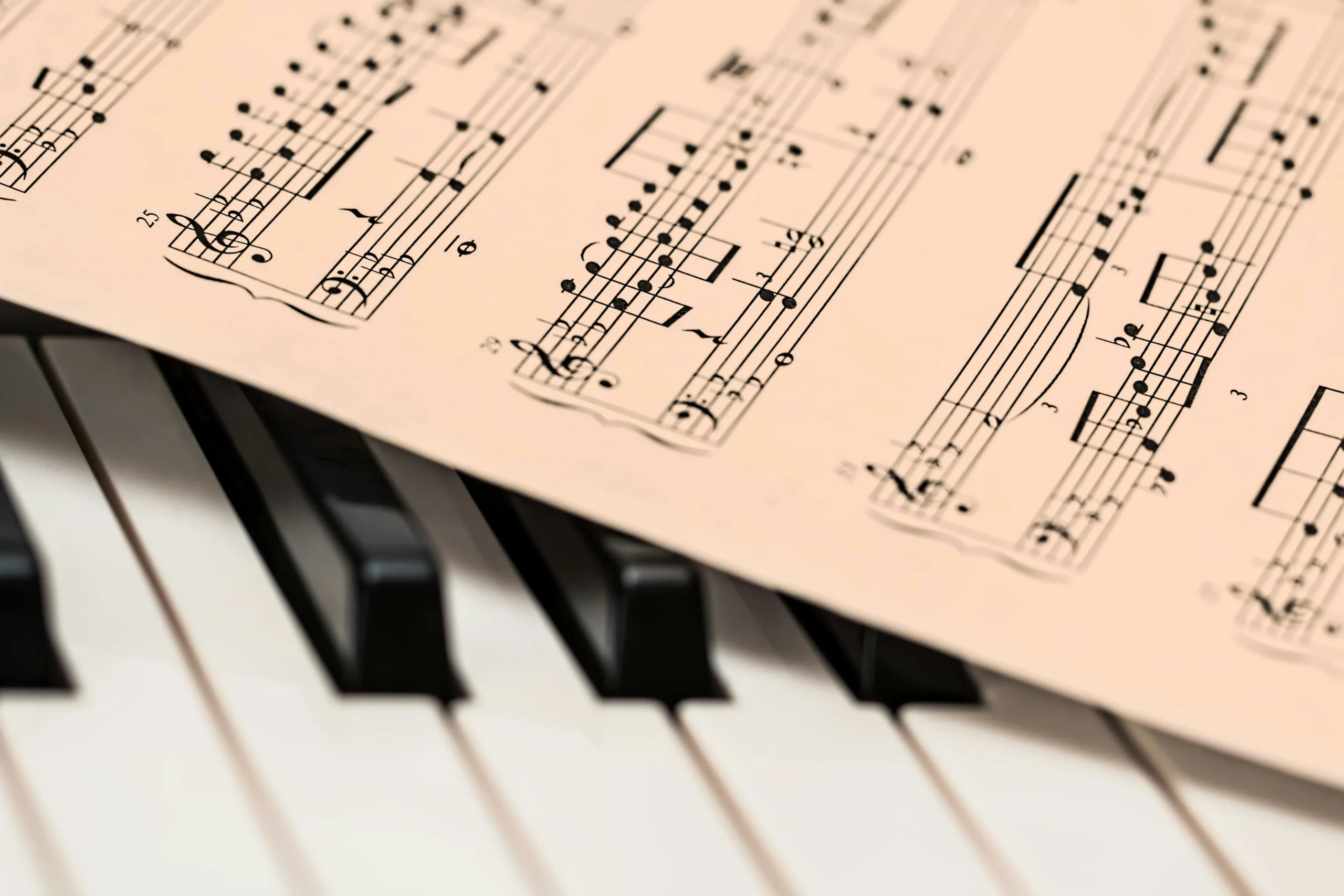 Hands positioned on piano keys with sheet music and metronome