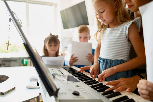 Piano teacher guiding young student through first piano lesson fundamentals
